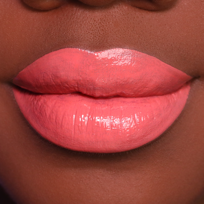 Dreamy coral nude lipstick on lips, medium-deep skin tone