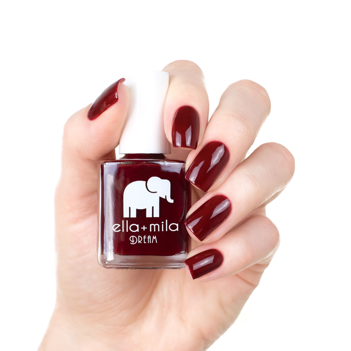 Nightdreamer wine red nail polish manicure on a light skin tone with the bottle